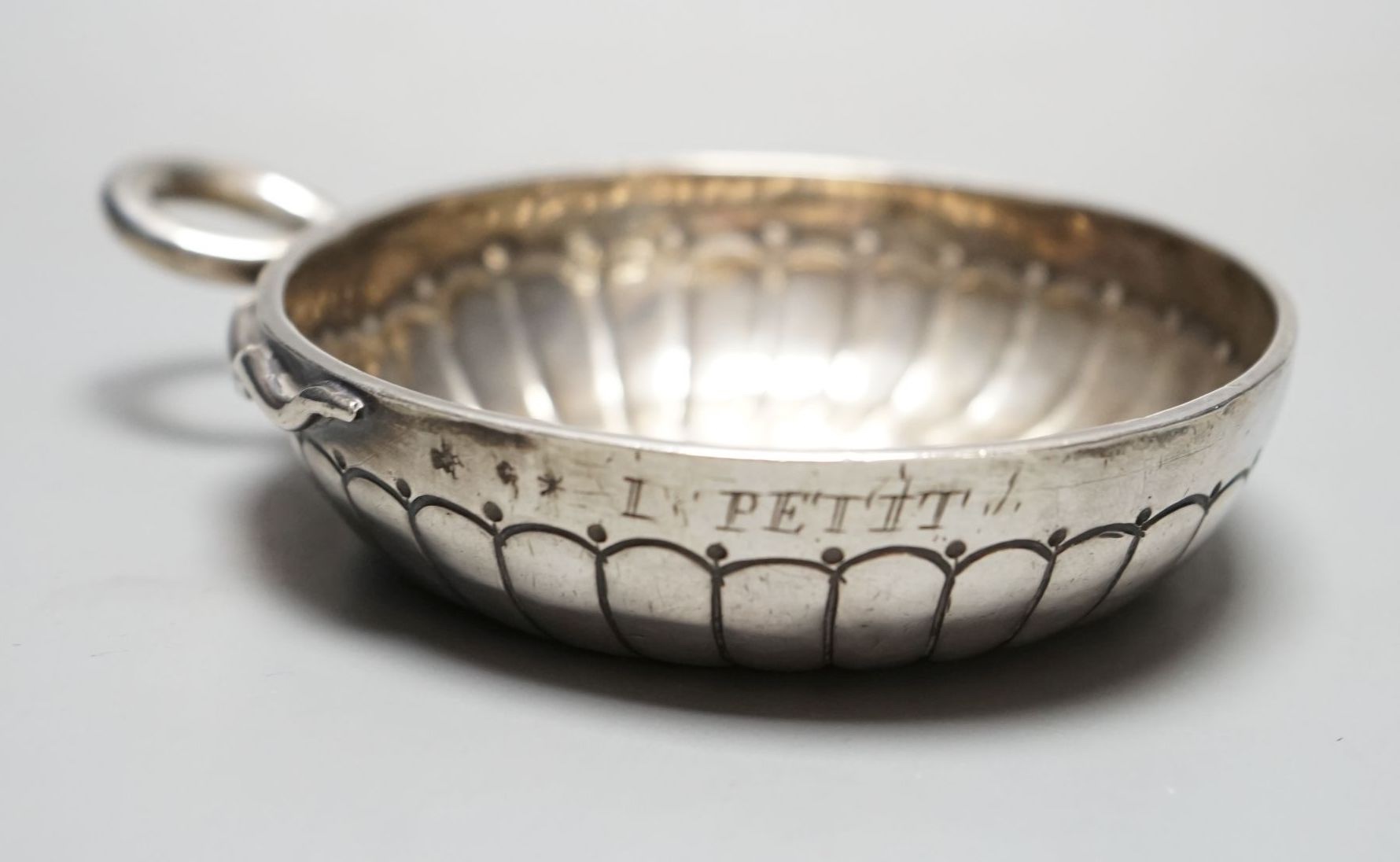 A late 18th/early 19th century French white metal taste vin, with engraved inscription and ring handle, 11.6cm over handle, 122 grams.